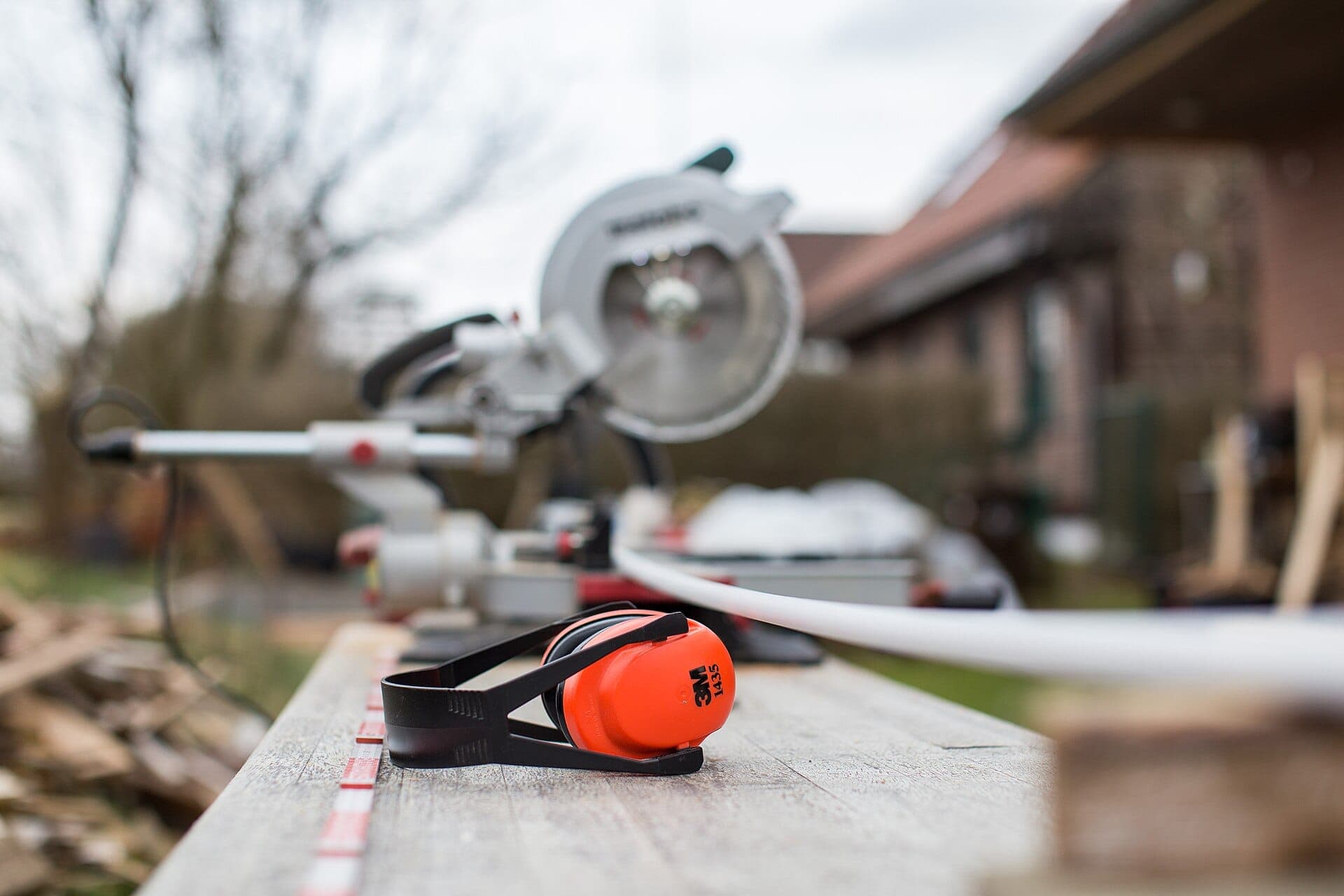 Chantier en cours : scie à onglet et casque antibruit sur un établi